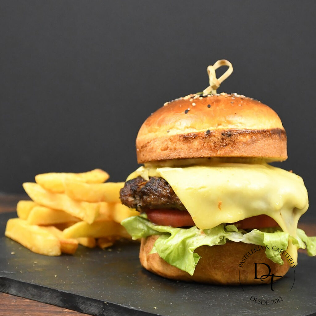 Hamburguesa de carne 180 gr, queso edam, lechuga, tomate y papas fritas, salsas a elección.