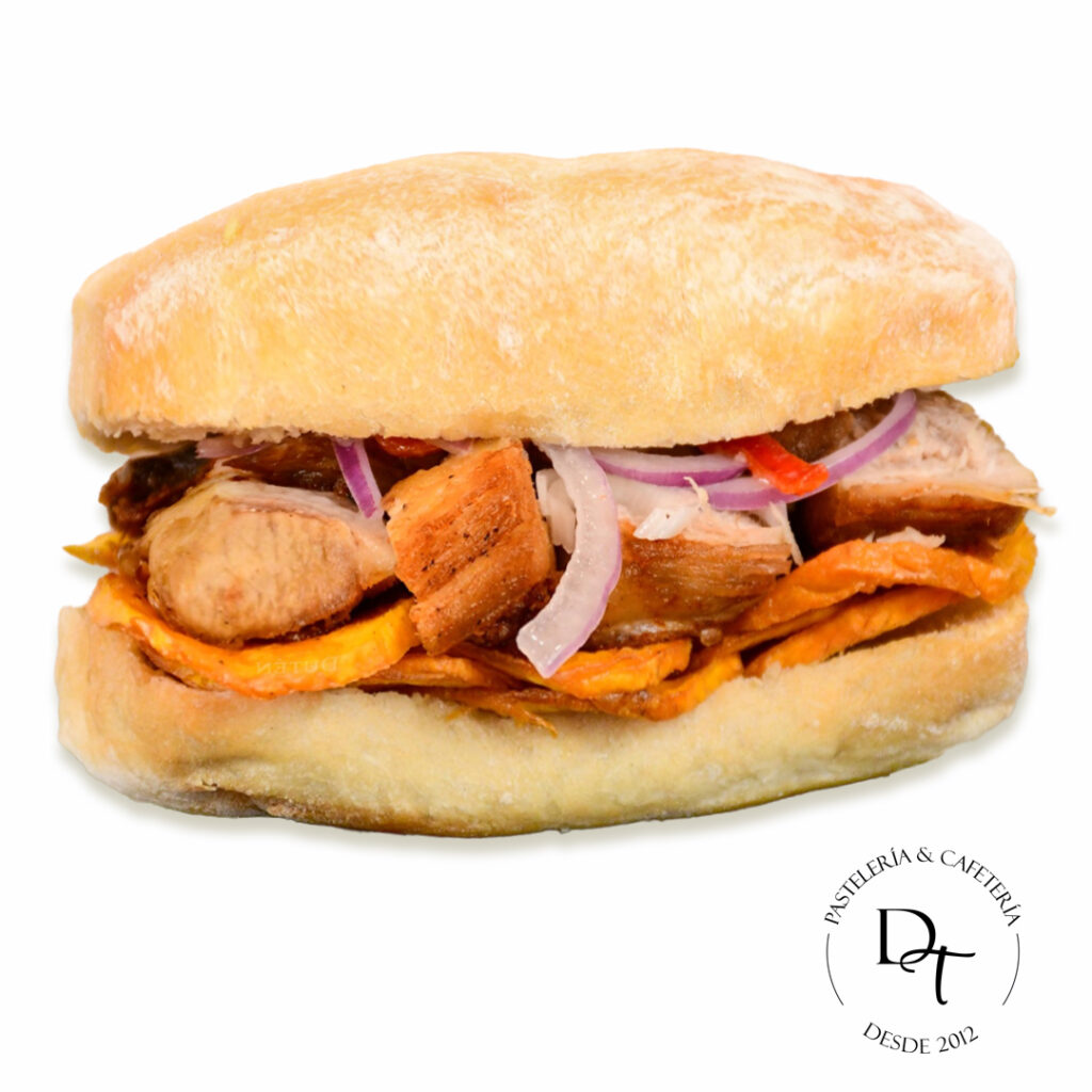 Pan ciabatta con masa madre, carne de cerdo, camote frito y salsa criolla de la casa Pan con chicharron